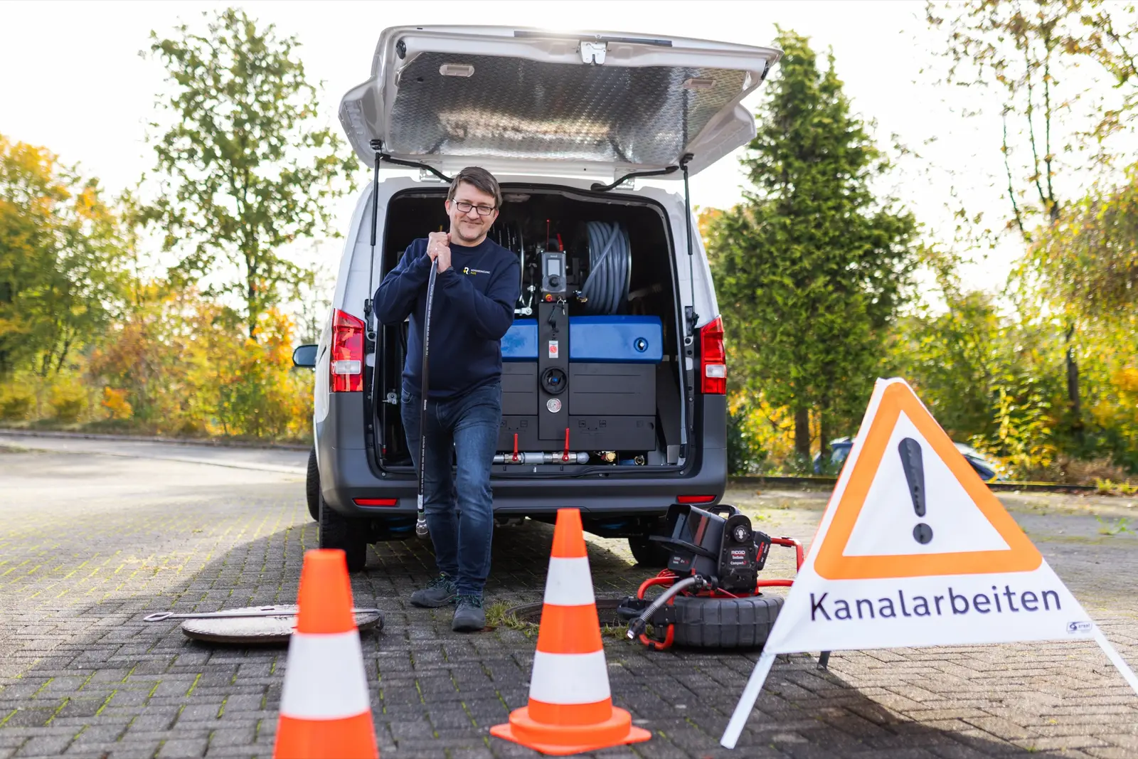 Einsatzfahrzeug mit Spültechnik an einem abgesicherten Kanalschacht