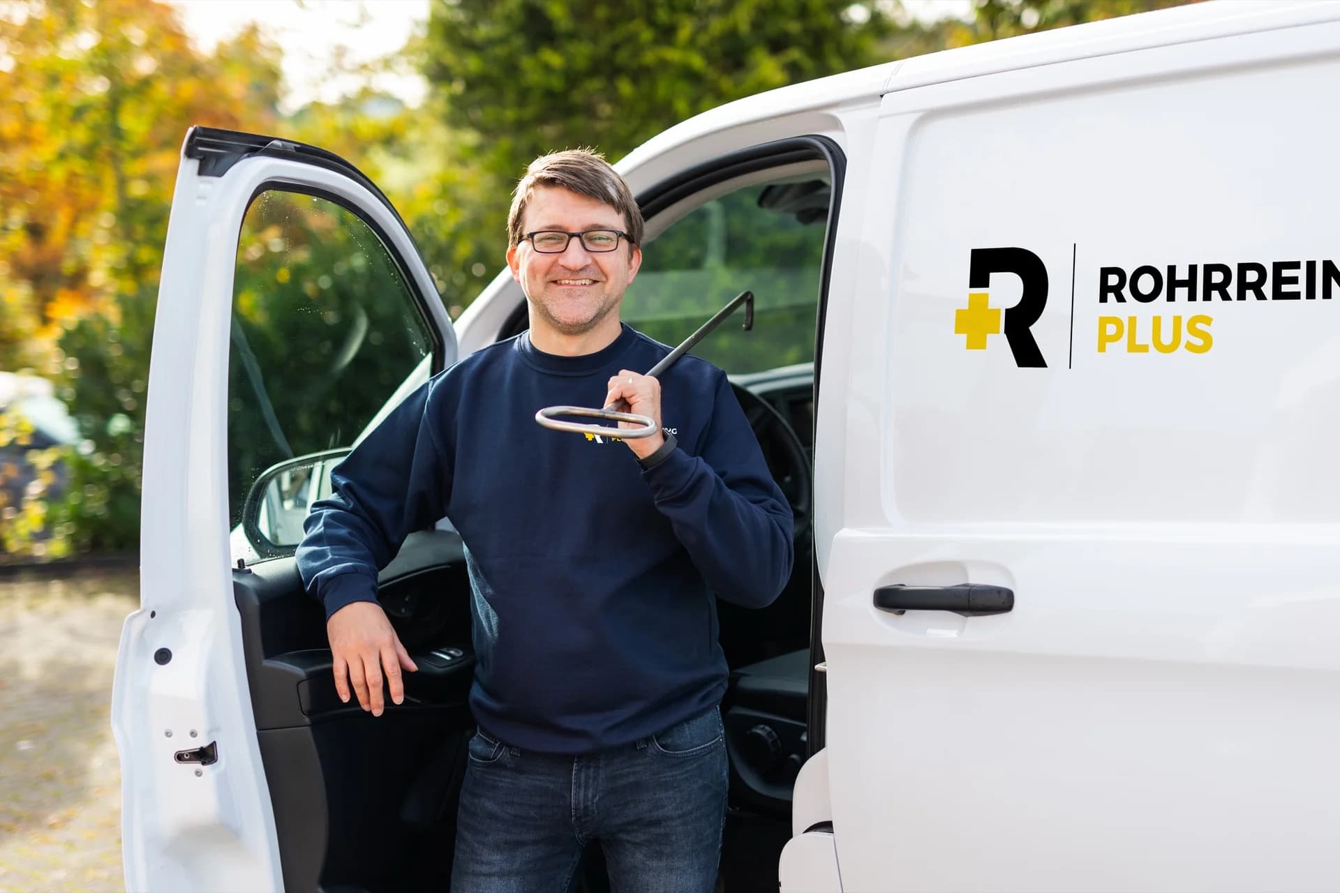 Techniker mit Reinigungsspirale am Fahrzeug von Rohrreinigung Plus